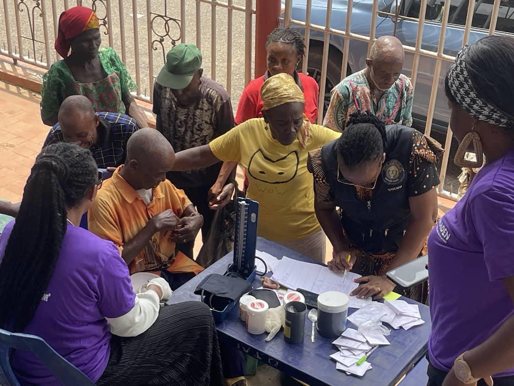 Senior citizens gathered at a registration table staffed by health workers during a free medical outreach