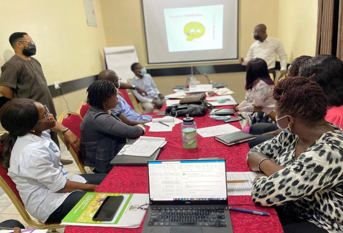 Participants seated around a conference table with laptops during an ILPI training workshop